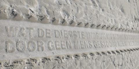 Schriftsteen in zand